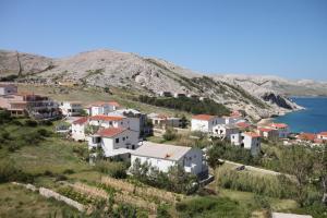 a village on a hill next to the water at Apartments and rooms with parking space Metajna, Pag - 6369 in Metajna
