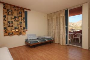 a bedroom with a bed and a sliding glass door at Apartments and rooms with parking space Metajna, Pag - 6369 in Metajna