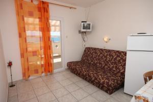 een woonkamer met een bank en een koelkast bij Apartments with a parking space Kustici, Pag - 6287 in Kustići