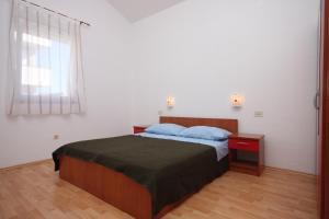 a bedroom with a bed with blue pillows and a window at Apartments and rooms with parking space Novalja, Pag - 6341 in Novalja