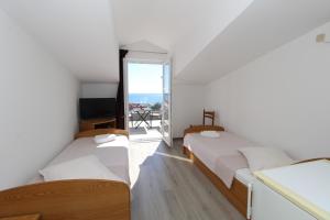 two beds in a room with a view of the ocean at Apartments and rooms with parking space Mandre, Pag - 6309 in Kolan