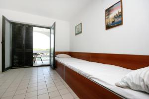 a bedroom with two beds and a balcony at Seaside apartments with a swimming pool Potocnica, Pag - 6407 in Borovići