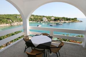 a balcony with a table and chairs and a view of the water at Seaside apartments with a swimming pool Potocnica, Pag - 6407 in Borovići