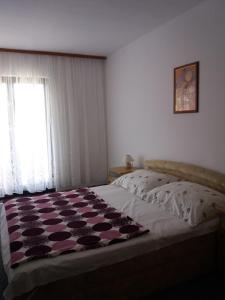 Un dormitorio con una cama con una manta. en Apartments with a parking space Pag - 6367 en Pag