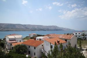 eine Gruppe von Häusern mit einem See im Hintergrund in der Unterkunft Apartments with a parking space Pag - 6367 in Pag