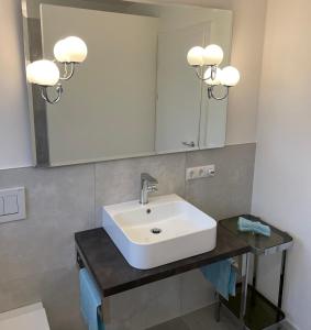 bagno con lavandino bianco e specchio di Bed&Bike Bruneck - Brunico a Brunico
