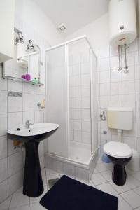 uma casa de banho com um chuveiro, um lavatório e um WC. em Apartments with a parking space Pag - 6326 em Pag