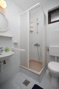 uma casa de banho com um chuveiro, um WC e um lavatório. em Apartments with a parking space Pag - 6326 em Pag