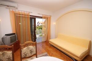 a bedroom with a bed and a tv and a window at Apartments and rooms with parking space Vodice - 6260 in Vodice