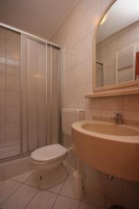a bathroom with a toilet and a sink and a shower at Apartments with a parking space Novalja, Pag - 6398 in Novalja