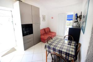 a kitchen with a table and a chair and a couch at Apartments by the sea Mandre, Pag - 6373 in Kolan