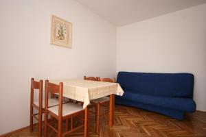 a dining room with a table and a blue couch at Apartments by the sea Stara Novalja, Pag - 6375 in Novalja +54 photos