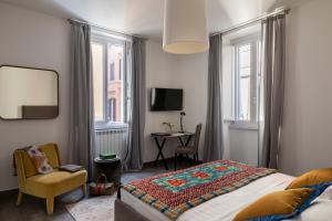 a bedroom with a bed and a chair and a table at Now Apartments, ApartHotel in the heart of Rome in Rome