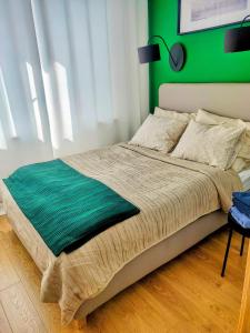 1 dormitorio con 1 cama con pared verde en Zielony apartament z widokiem na jezioro, en Złotów