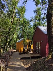 a red shed with a picnic table in the woods at Cabanas da Ulla in Touro