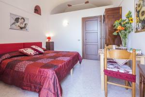 ein Schlafzimmer mit einem Bett, einem Tisch und einem Stuhl in der Unterkunft Il Rifugio del Poeta in Ravello
