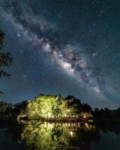 una vista nocturna de la Vía Láctea sobre un cuerpo de agua en Tad Lo - FANDEE ISLAND - Bolaven Loop Pakse, en Ban Kiangtat