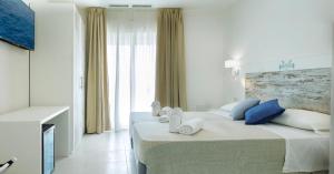 Ein Bett oder Betten in einem Zimmer der Unterkunft Mercury Beach Hotel