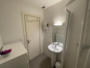 een witte badkamer met een wastafel en een douche bij Immodelpas Griffon in Pas de la Casa