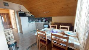 a kitchen and dining room with a table and chairs at Víkendový Dom U Vasila in Krahule