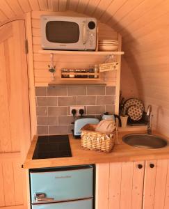 a small kitchen with a microwave and a sink at Finest Retreats - Prosecco Cabin in East Looe