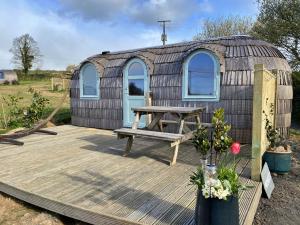 a yurt with a picnic table on a deck at Finest Retreats - Prosecco Cabin in East Looe