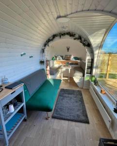 a living room with a green couch and a table at Finest Retreats - Proper Job Cabin in East Looe