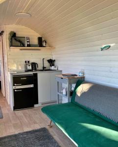 a room with a kitchen with a bed and a table at Finest Retreats - Proper Job Cabin in East Looe
