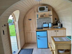 a small kitchen with an arched doorway and a microwave at Finest Retreats - The Pasty Cabin in East Looe