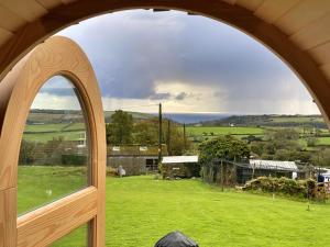 an arched window looking out onto a green field at Finest Retreats - The Pasty Cabin in East Looe