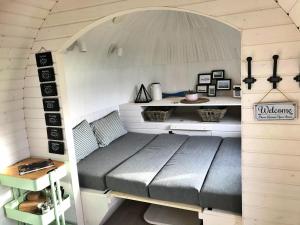 a bed in a tiny house with a table at Finest Retreats - The Pilchard Cabin in East Looe