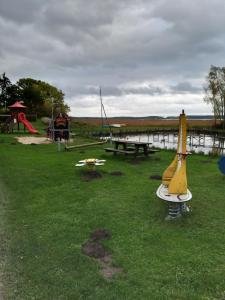 a playground with a yellow surfboard on the grass at Ferienhaus Alla, Neeberg/Usedom in Neeberg