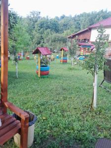 um parque com um parque infantil com árvores e um banco em Casa Ion em Horezu