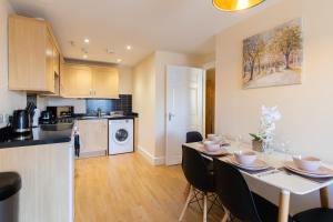 uma cozinha e sala de jantar com mesa e cadeiras em Velvet 1-bedroom penthouse, Clockhouse, Hoddesdon em Hoddesdon