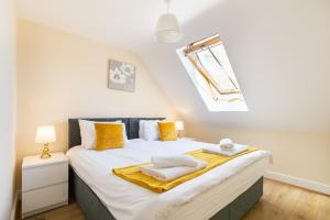 1 dormitorio con 1 cama grande con almohadas amarillas en Velvet 1-bedroom penthouse, Clockhouse, Hoddesdon en Hoddesdon