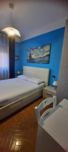 a bedroom with a large bed and a blue wall at Da Laura in Lucca