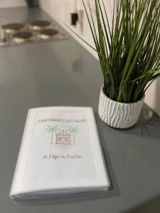 a book sitting on a table next to a potted plant at Santana's Getaway in Agnes Water