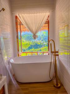 y baño con bañera y ventana. en สายหมอกบอกรัก น่าน SAIMOK Bokrak NAN, en Ban Huai Ti