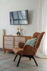 a brown chair in a living room with a dresser at Gemütliches Fachwerkhaus im Herzen Nideggens in Nideggen