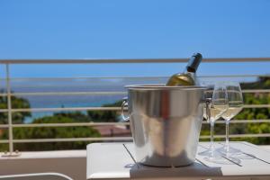聖安蒂奧科的住宿－Mercury Beach Hotel，桶装一瓶葡萄酒和两杯酒