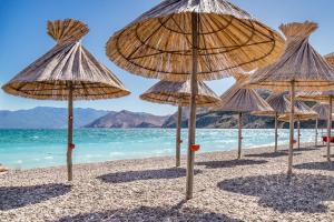 grupa słomianych parasoli na plaży w obiekcie Apartments with a parking space Baska, Krk - 19490 w Bašce