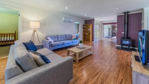 a living room with a couch and a tv at Loch Retreat 550M To Town in Inverloch