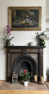 una chimenea con dos plantas y un cuadro encima en Double bedroom with en-suite bathroom in Chelsea - central London - share apartment en Londres