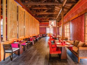 a dining room with tables and red chairs at Rixos Premium Tekirova - The Land of Legends Access in Tekirova