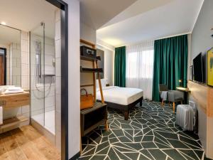 a hotel room with a bed and a bathroom at ibis Styles Aschaffenburg in Aschaffenburg