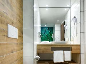 La salle de bains est pourvue d'un lavabo et d'un miroir. dans l'établissement ibis Styles Aschaffenburg, à Aschaffenbourg