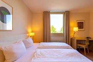 سرير أو أسرّة في غرفة في Dorint Hotel Durbach/Schwarzwald