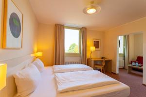 سرير أو أسرّة في غرفة في Dorint Hotel Durbach/Schwarzwald