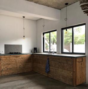 a kitchen with white walls and wooden counters and windows at Casa Palmeira in Lazareto
