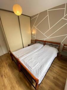 a large bed in a room with a ceiling at Murano Apartaments Nova Praga in Warsaw
